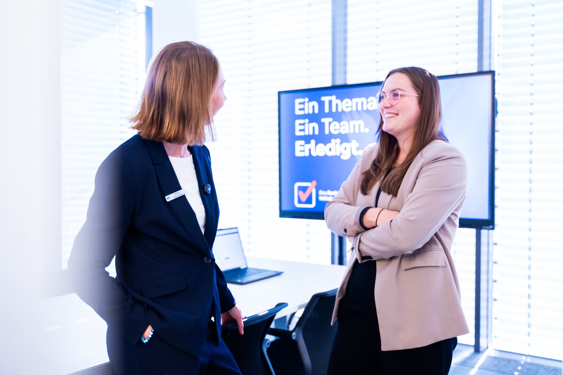 Zwei Beraterinnen des BusinessCenters im Gespräch vor dem Motto „Ein Thema. Ein Team. Erledigt.“