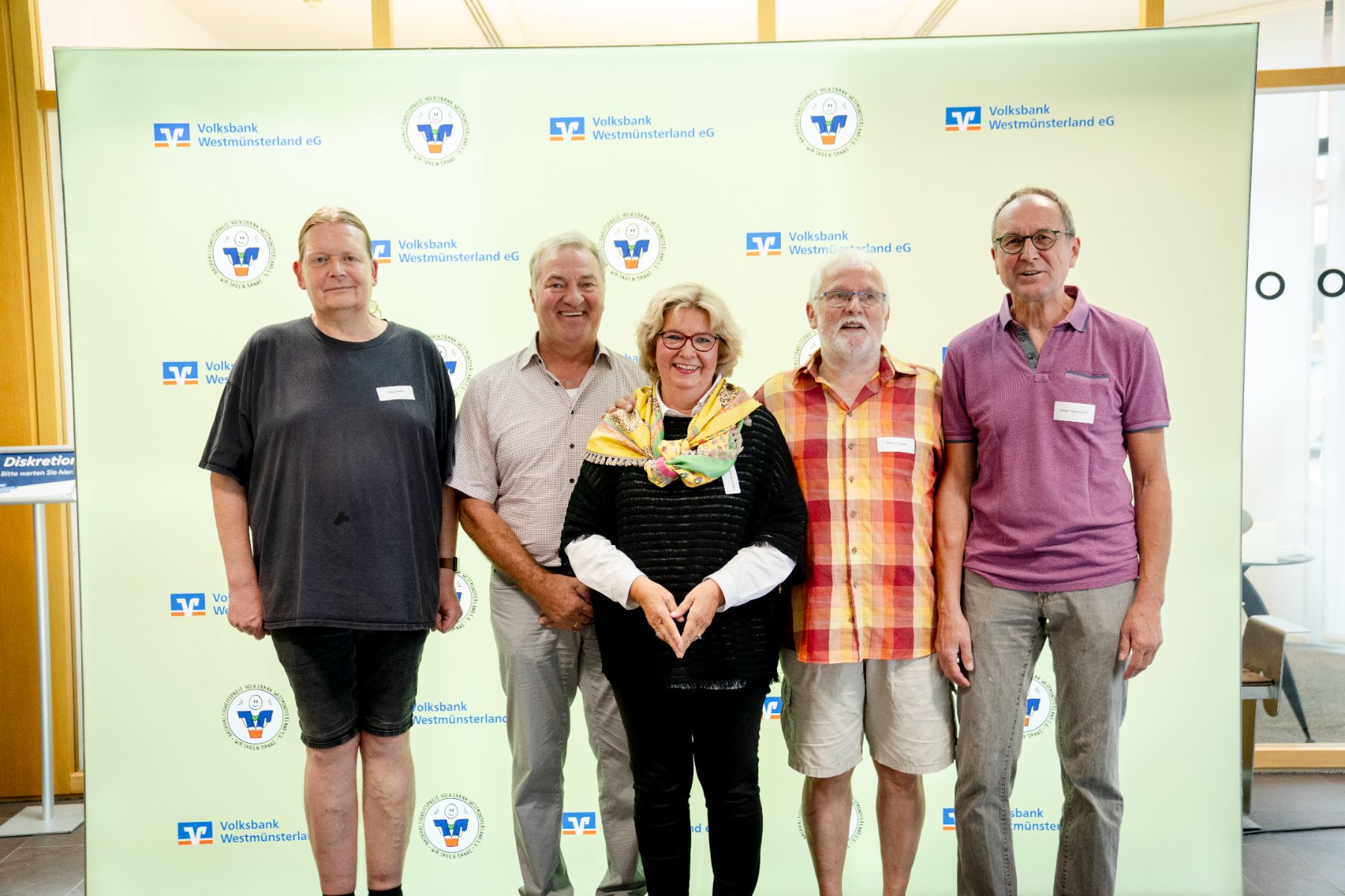 Fünf Preisträgerinnen und Preisträger vor der Fotowand